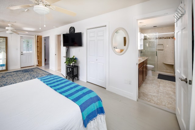 tiled bedroom with ceiling fan, connected bathroom, and a closet