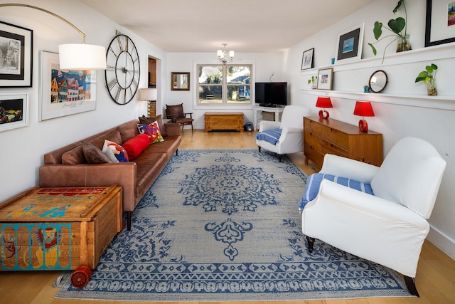 living room with light hardwood / wood-style floors and a notable chandelier