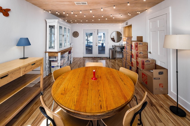 dining space with hardwood / wood-style floors, wood ceiling, and french doors