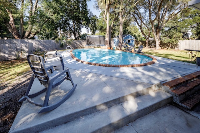 view of swimming pool with an outbuilding, a lawn, and a patio