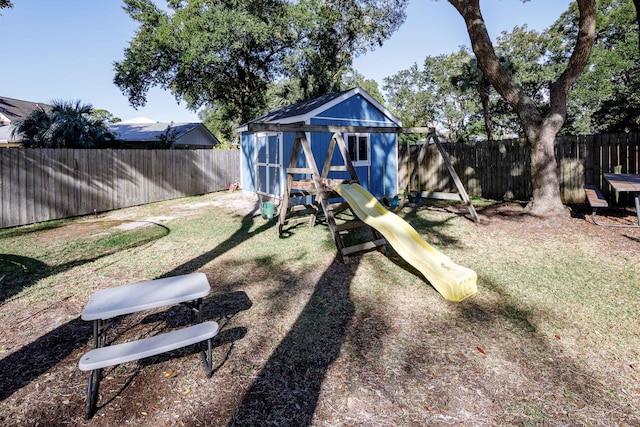 view of yard with a playground and a storage unit