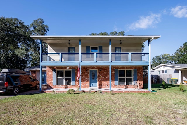 view of front of property featuring a patio area, a front yard, and a balcony