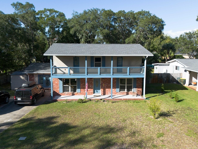 back of property featuring a patio area, a balcony, and a yard