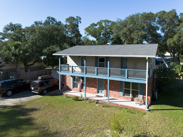 view of front of property with a patio area, a front lawn, and a balcony