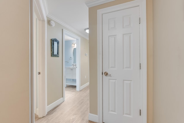 corridor featuring ornamental molding and light wood-type flooring