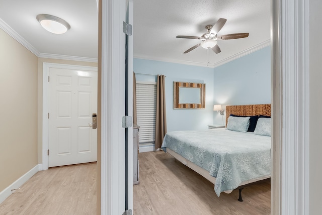 bedroom featuring ceiling fan, crown molding, and light hardwood / wood-style floors