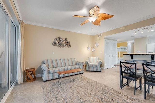 living room featuring light hardwood / wood-style floors, ornamental molding, and ceiling fan