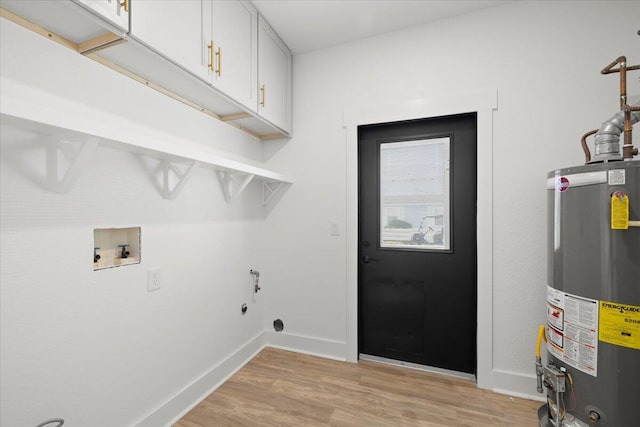 washroom featuring hookup for a washing machine, water heater, light hardwood / wood-style floors, electric dryer hookup, and cabinets