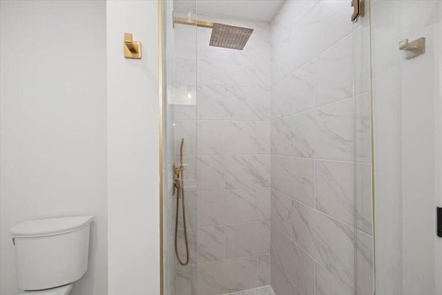 bathroom featuring tiled shower and toilet