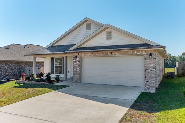 view of front of home with central air condition unit, a front yard, and a garage