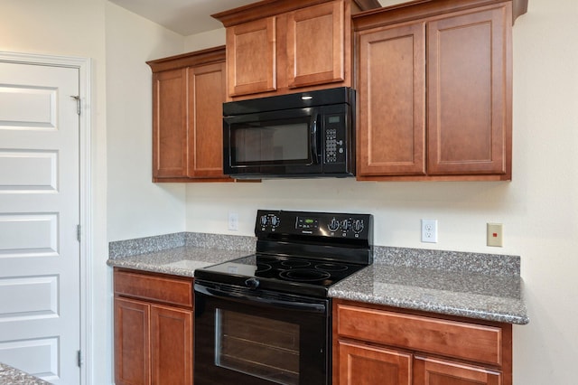 kitchen featuring light stone countertops and black appliances