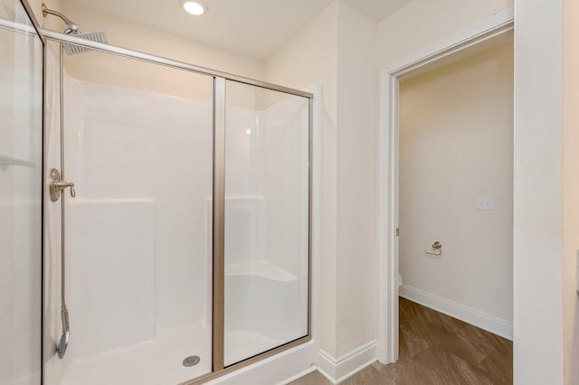 bathroom featuring a shower with door and toilet