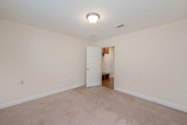 unfurnished room featuring light carpet