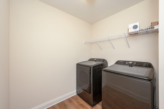 washroom with light hardwood / wood-style floors and washing machine and clothes dryer