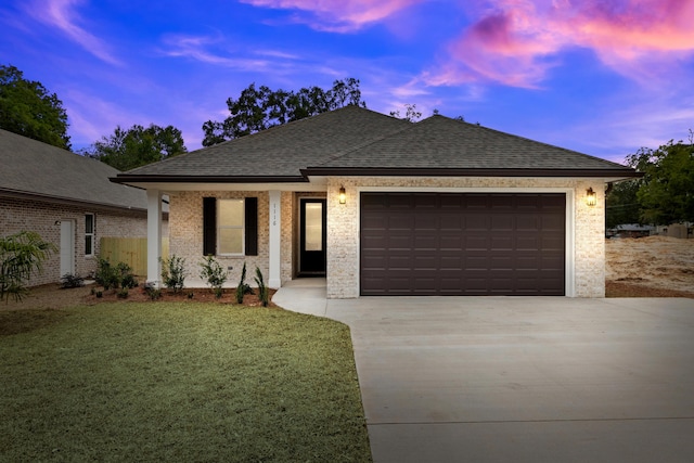 view of front of property featuring a garage and a lawn