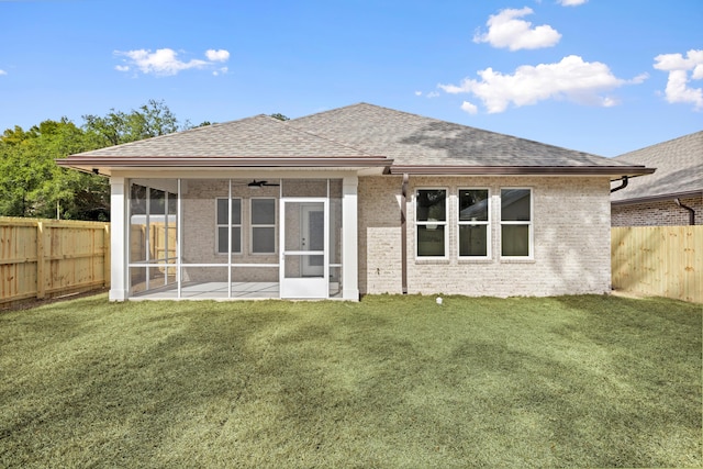 back of house featuring ceiling fan, a sunroom, and a lawn