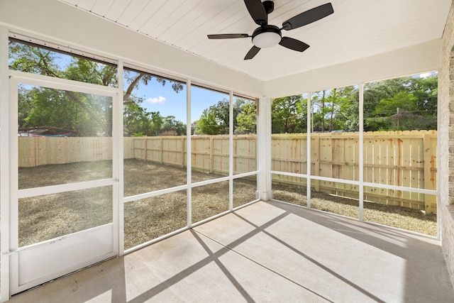 unfurnished sunroom featuring ceiling fan and plenty of natural light