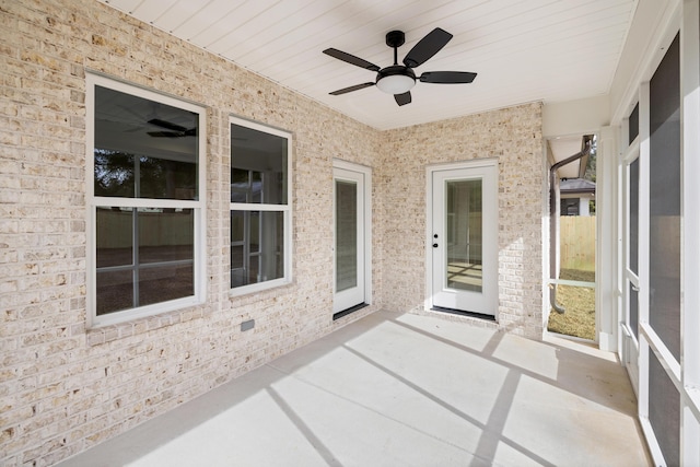 unfurnished sunroom featuring ceiling fan