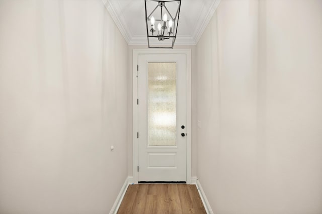 doorway to outside with light wood-type flooring, an inviting chandelier, and ornamental molding