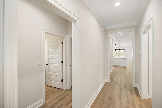 hallway featuring ornamental molding and light wood-type flooring