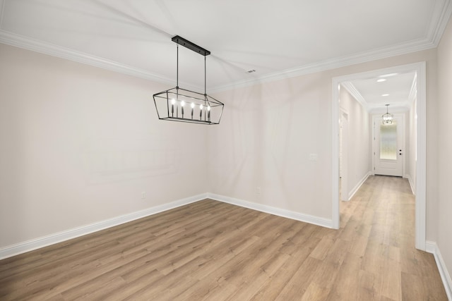 unfurnished dining area featuring ornamental molding, light hardwood / wood-style flooring, and a notable chandelier