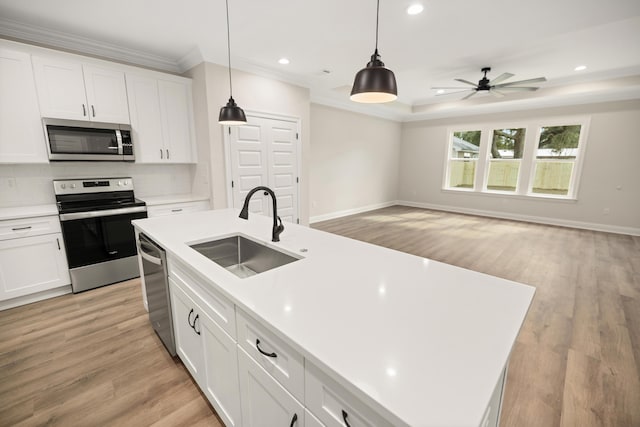 kitchen featuring appliances with stainless steel finishes, a kitchen island with sink, white cabinetry, and sink