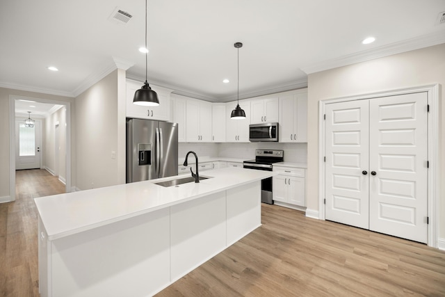 kitchen with sink, white cabinets, a center island with sink, and stainless steel appliances