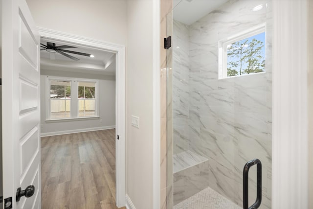 bathroom with hardwood / wood-style flooring, plenty of natural light, walk in shower, and ceiling fan