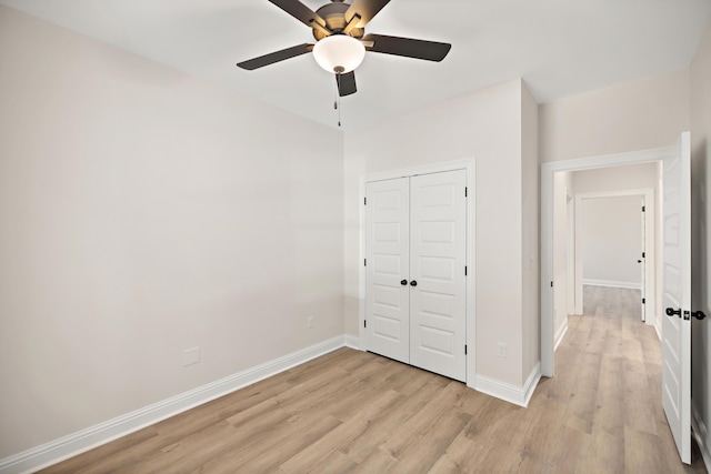 unfurnished bedroom featuring ceiling fan, a closet, and light hardwood / wood-style flooring