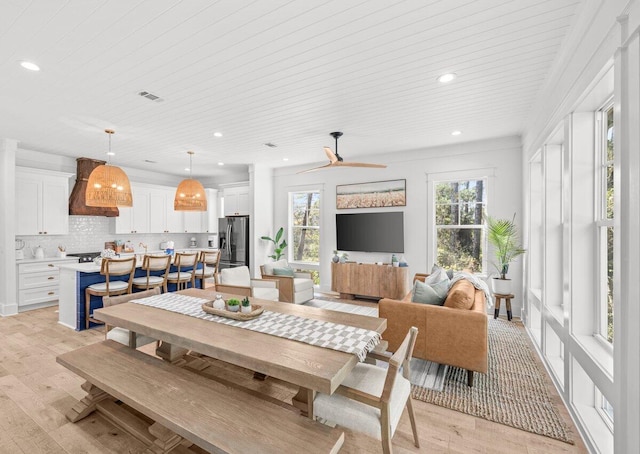 dining space with light hardwood / wood-style floors and ceiling fan