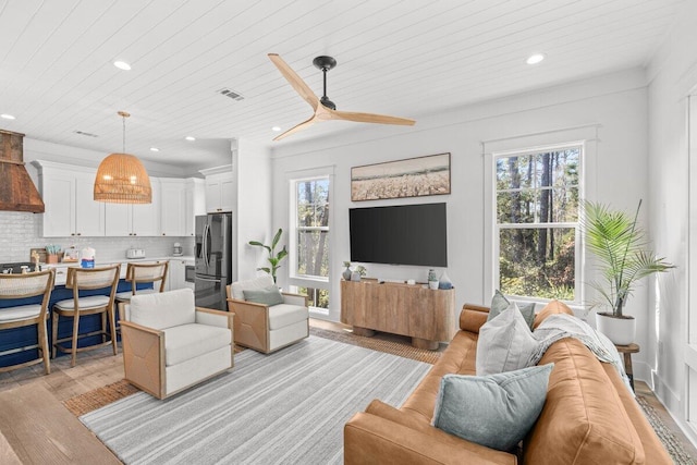 living room with ceiling fan, wooden ceiling, and light hardwood / wood-style floors