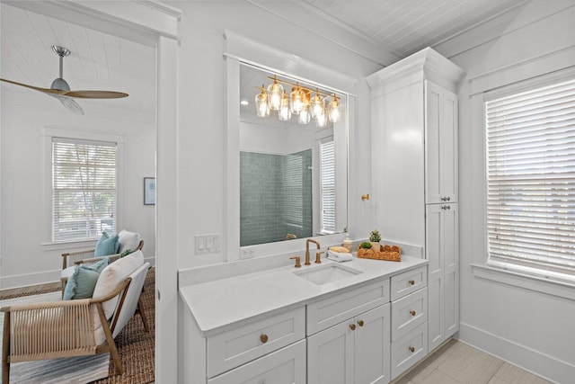 bathroom with vanity, ceiling fan, crown molding, and a shower