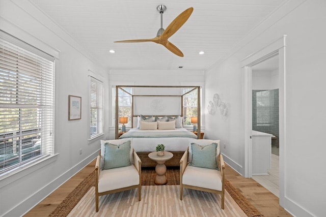 bedroom featuring ceiling fan, crown molding, multiple windows, and light wood-type flooring