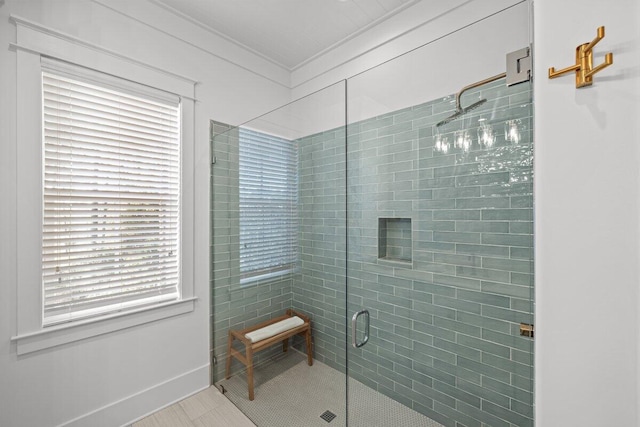 bathroom featuring crown molding, a shower with shower door, and a wealth of natural light