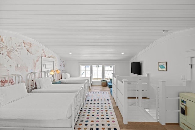 bedroom featuring light hardwood / wood-style flooring, wooden ceiling, crown molding, and vaulted ceiling