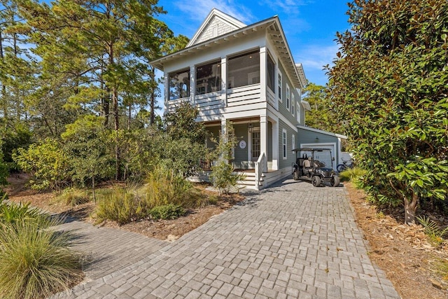 view of front facade featuring an outdoor structure, a porch, and a garage