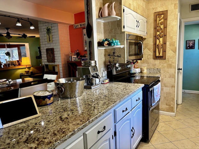 kitchen with white cabinetry, electric range, light stone countertops, ceiling fan, and light tile patterned floors