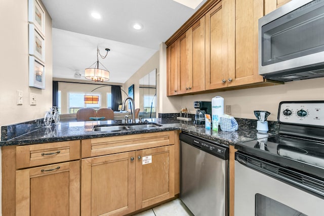 kitchen with appliances with stainless steel finishes, dark stone countertops, light tile patterned flooring, a notable chandelier, and sink