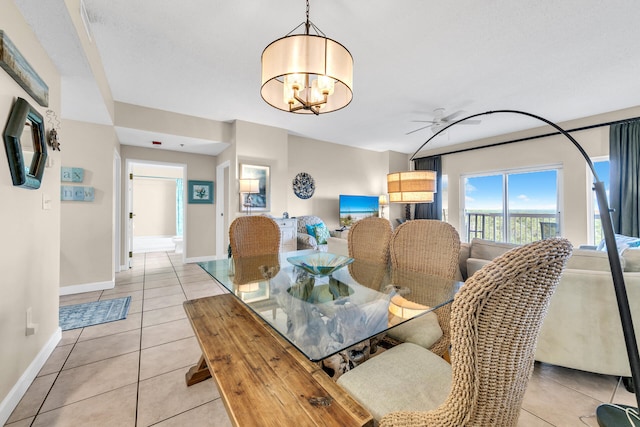 tiled dining space with ceiling fan with notable chandelier