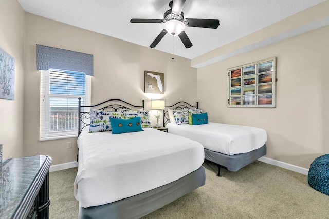 carpeted bedroom featuring ceiling fan and a textured ceiling