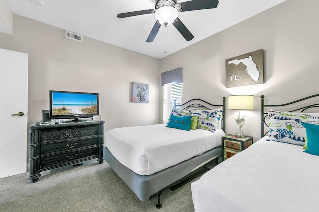 carpeted bedroom featuring a textured ceiling and ceiling fan