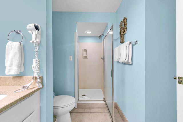 bathroom with a textured ceiling, walk in shower, toilet, vanity, and tile patterned flooring