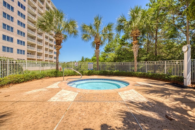 view of swimming pool featuring a hot tub