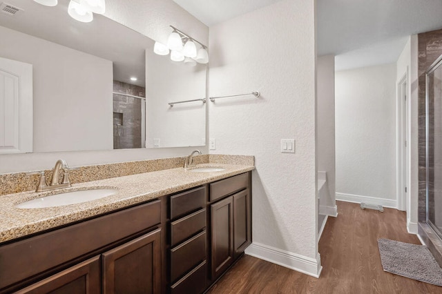 bathroom featuring vanity, an enclosed shower, and hardwood / wood-style flooring