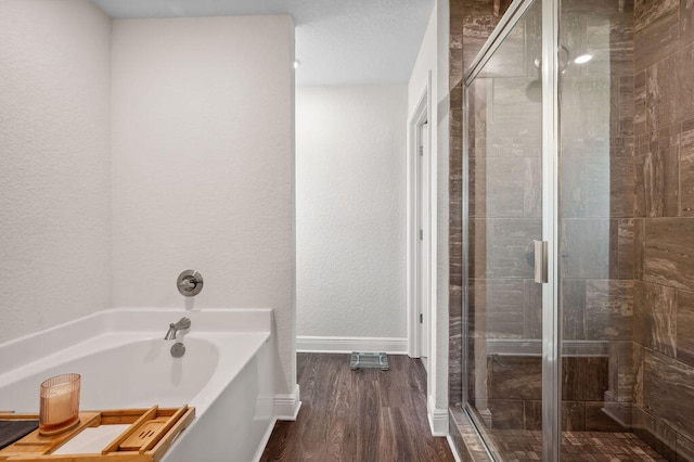 bathroom with hardwood / wood-style floors and shower with separate bathtub