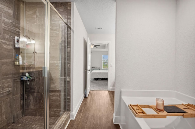 bathroom featuring hardwood / wood-style floors, walk in shower, and ceiling fan