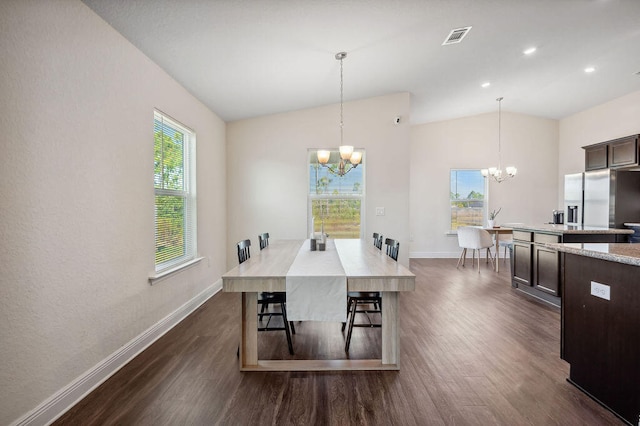 dining area featuring a wealth of natural light, dark wood-type flooring, vaulted ceiling, and a chandelier