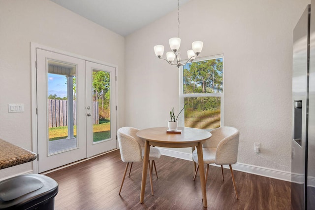 dining room with french doors, a notable chandelier, vaulted ceiling, and dark hardwood / wood-style flooring