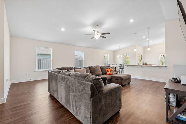 living room with dark wood-type flooring, vaulted ceiling, and ceiling fan with notable chandelier