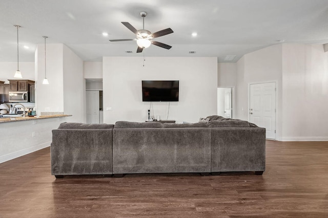 living room featuring dark wood-type flooring and ceiling fan